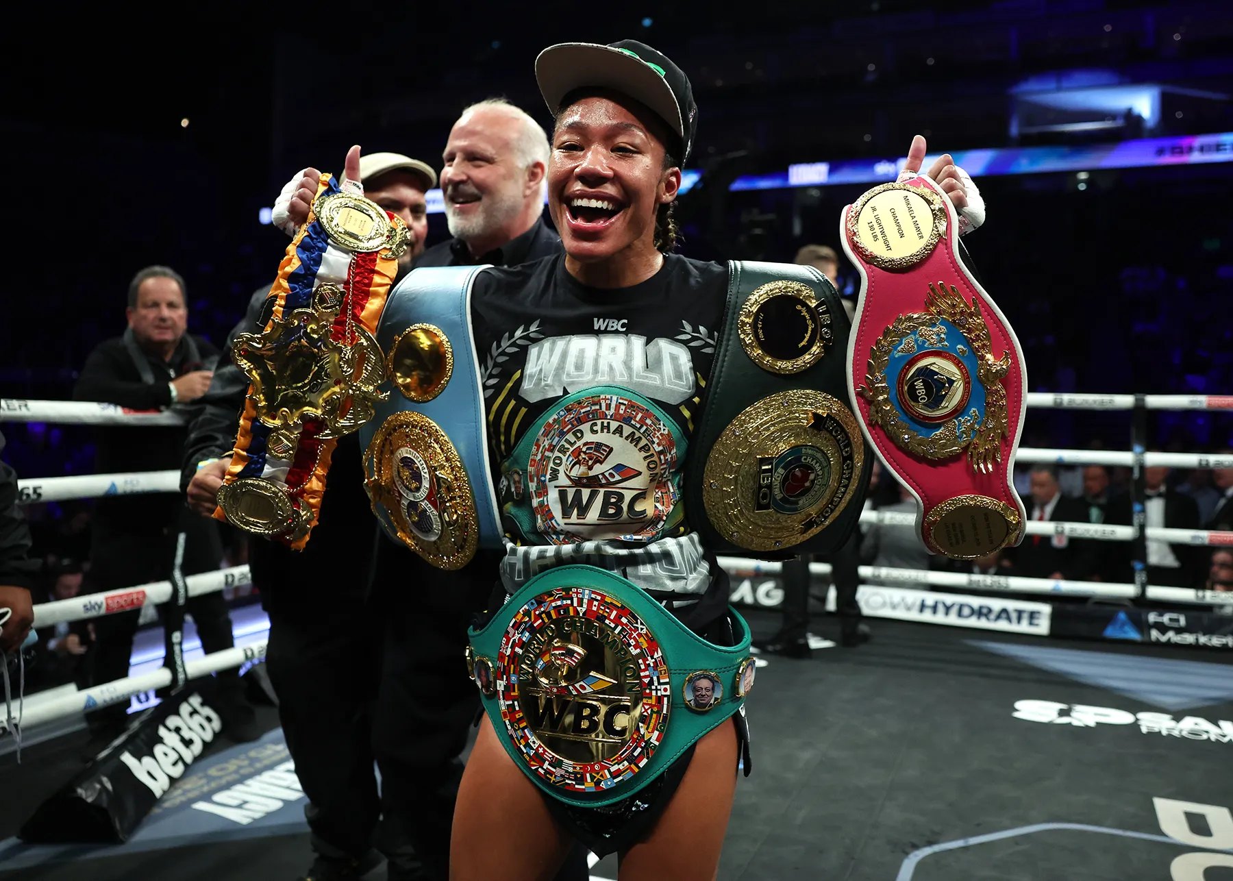 Alycia Baumgardner celebrating in the ring with her championship belts